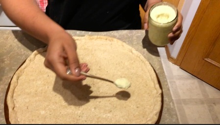 Adding ginger garlic paste on pizza