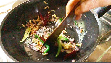 add red chillies, green chillies, crushed mixture (garlic, ginger, cumin), onion and curry leaves.