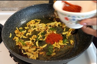 Adding chilli powder to the pan